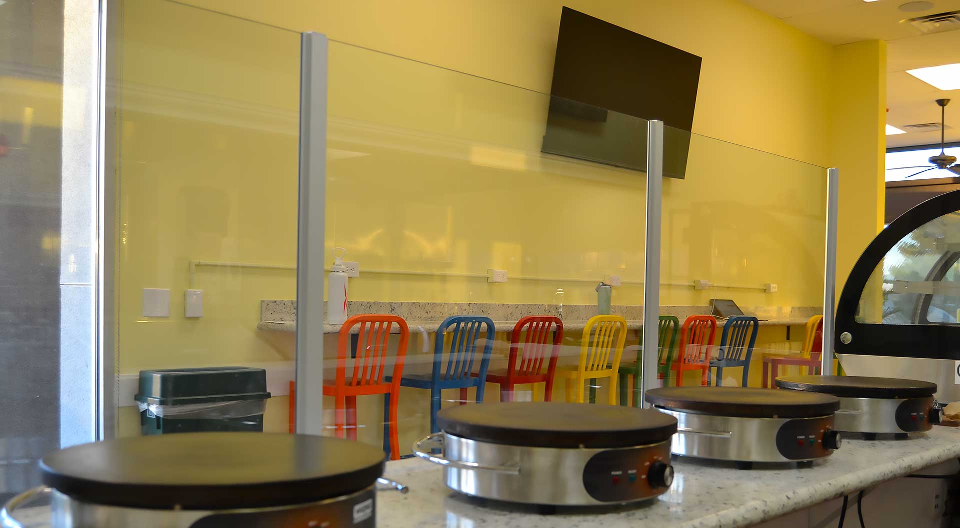 Inside Daré Vita Café, vibrant chairs line a counter against a yellow wall, with crepe makers in the foreground, reflecting the café's allergen-friendly and fresh, plant-based dining focus.| Daré Vita Café | Las Vegas